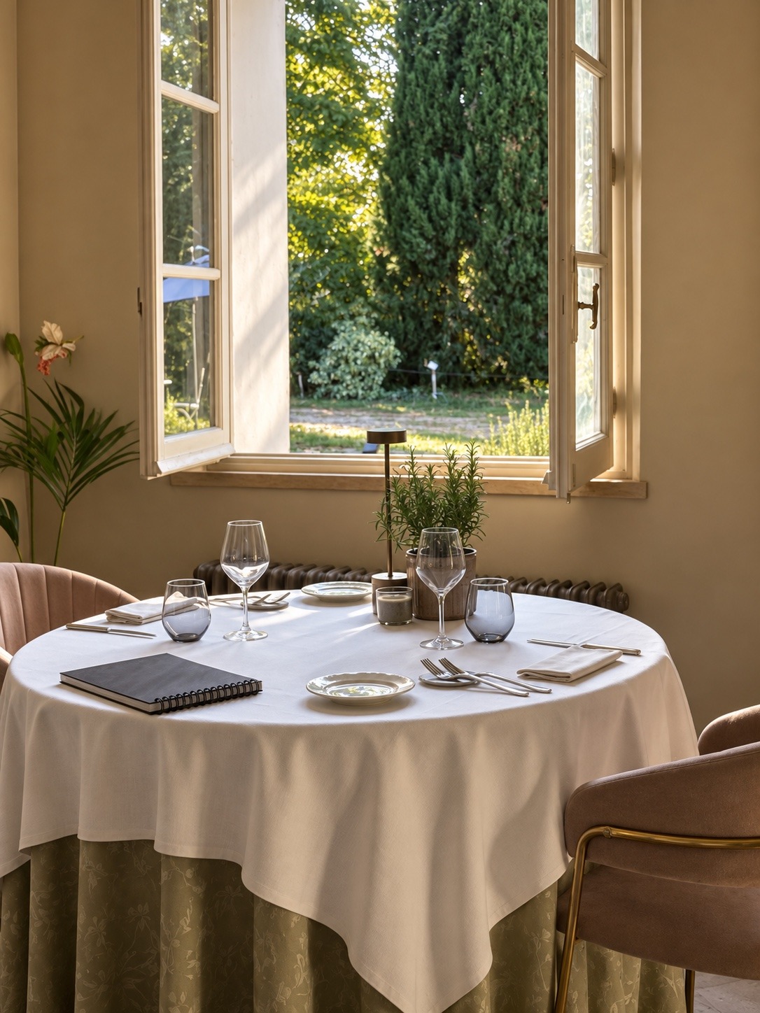 Tavolo apparecchiato nel ristorante Terracqua accanto a una finestra aperta sul giardino